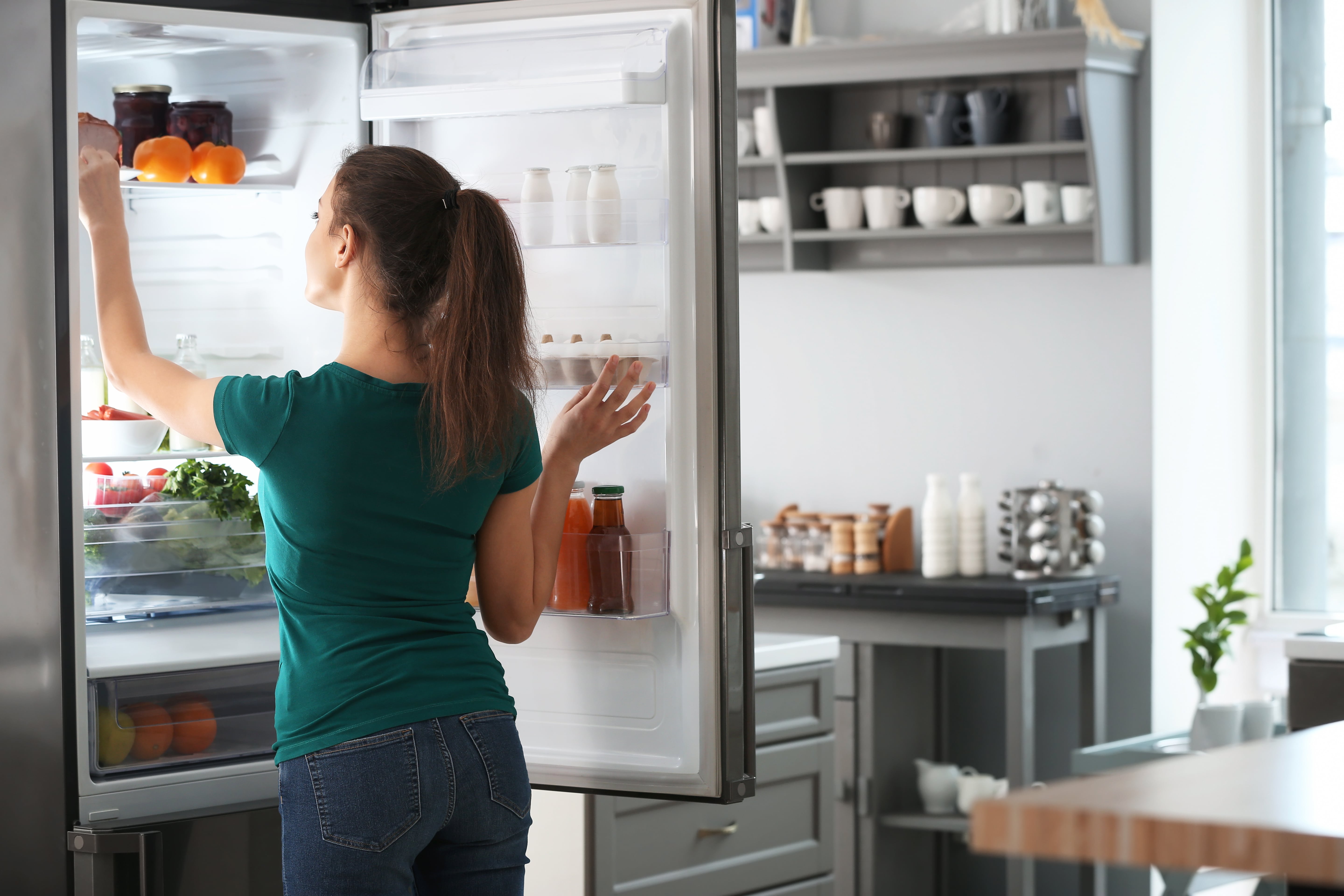 naine avatud külmkapi ees
